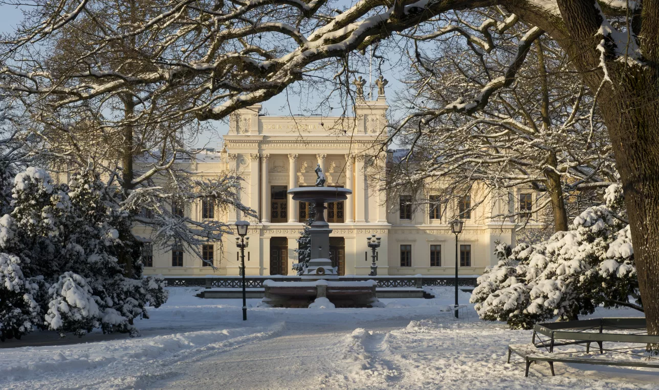 Universitetshuset fotat från avstånd en solig vinterdag med mycket snö. Foto